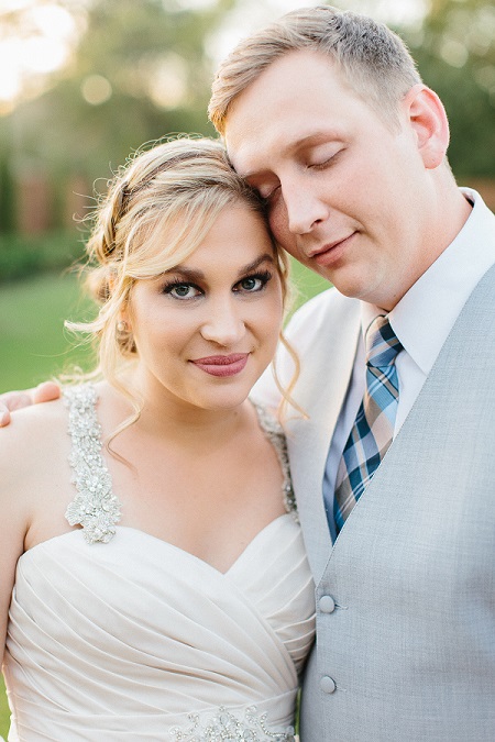 A blonde woman in a sparkling wedding dress with a handsome man in a grey suit